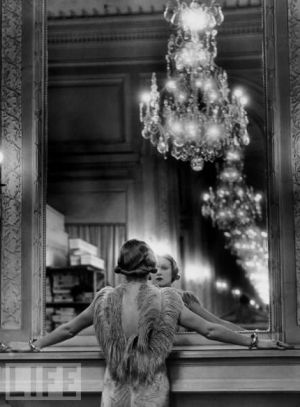 Model staring at herself in mirror with chandelier.jpg